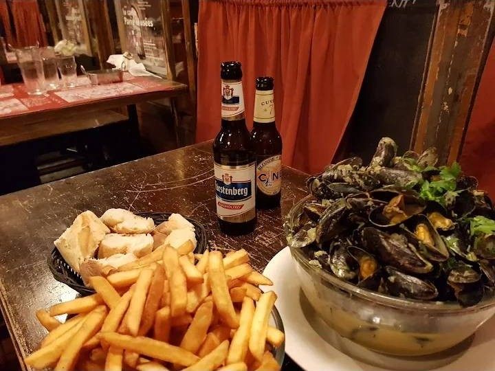 Moules, frites et bières sur une table en bois